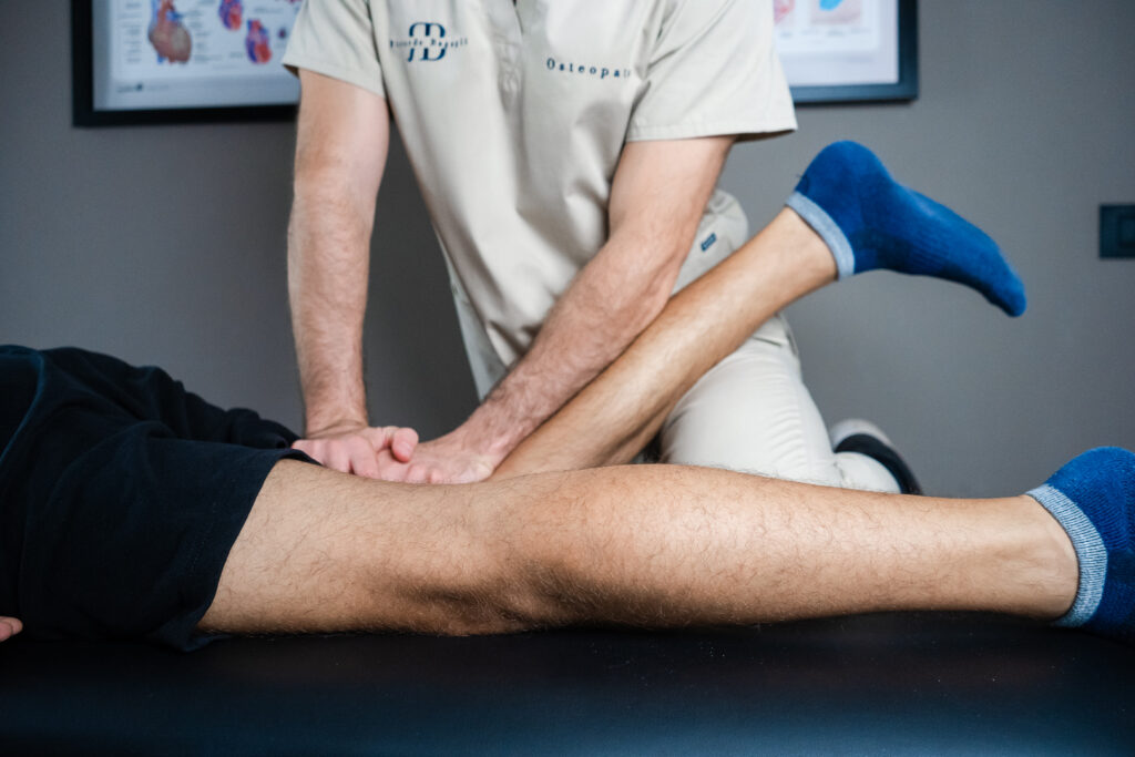 osteopata tratta gamba di uno sportivo per prevenire gli infortuni